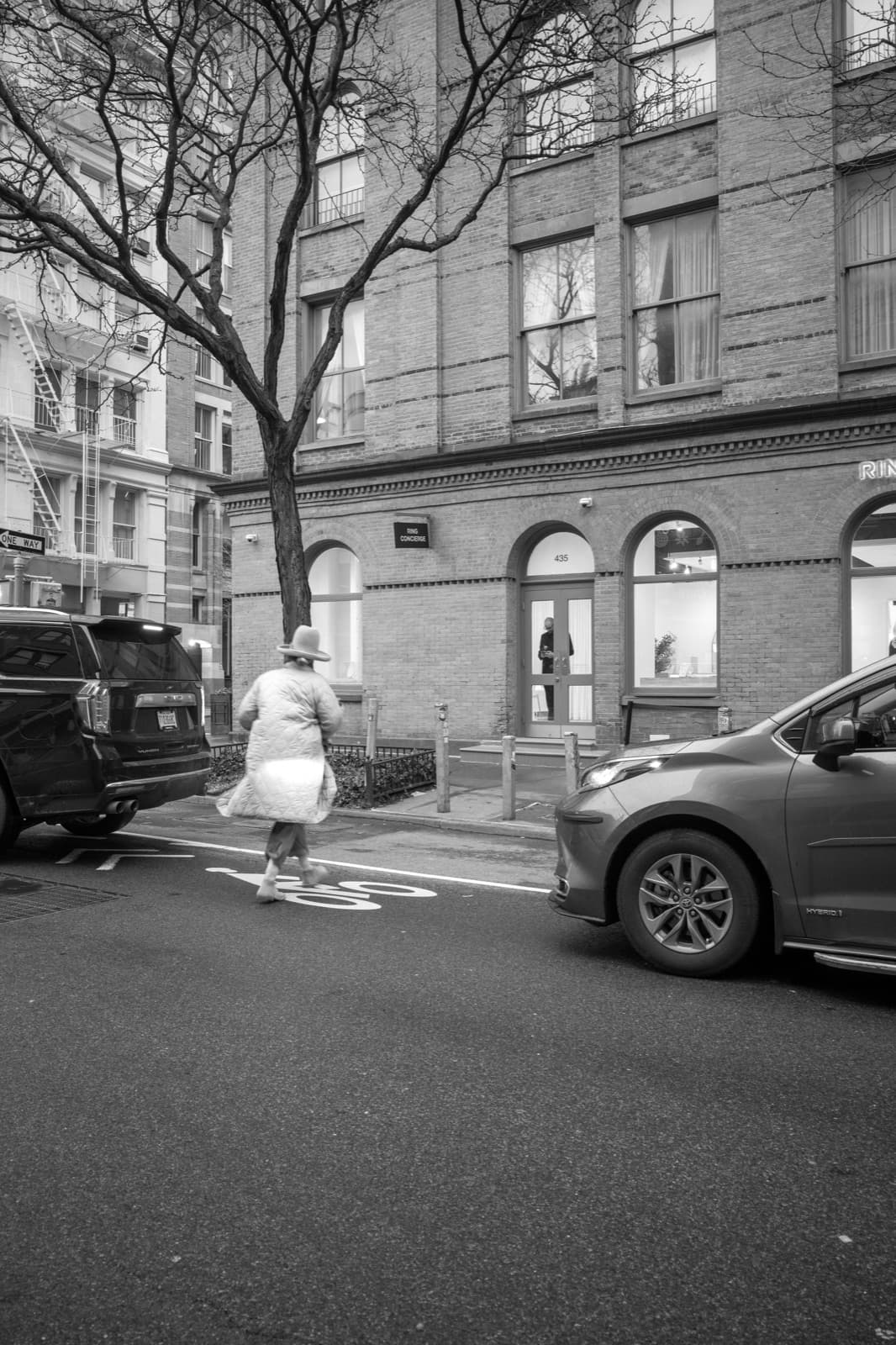A runner crosses a New York street as a car waits in the foreground.